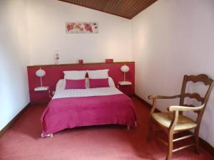 AudresseinAuberge Audressein的卧室配有粉红色的床和椅子