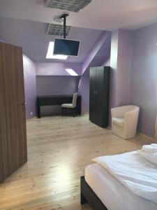 OryakhovoThe Old House的一间卧室设有紫色的墙壁、一张床和一张书桌