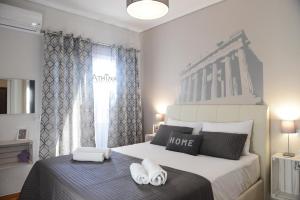 雅典雅典娜公寓的一间卧室配有一张床,上面有两条毛巾