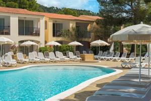 帕格拉菲格斯俱乐部欧罗巴度假酒店的一个带椅子和遮阳伞的游泳池的度假酒店