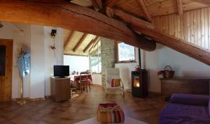 OzeinAppartamenti Grivola的一间带木制天花板的客厅和一间餐厅