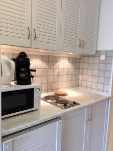 巴拉顿菲赖德科斯托拉尼公寓酒店的厨房配有白色橱柜和炉灶烤箱。