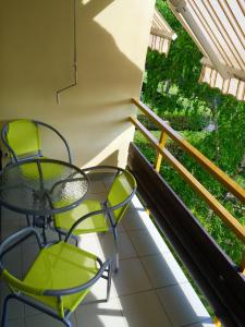 巴拉顿菲赖德科斯托拉尼公寓酒店的阳台配有2把椅子和桌子