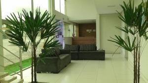 泰谢拉迪弗雷塔斯Hotel Vento Sul的客厅配有两张沙发和两棵棕榈树