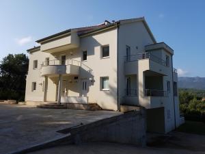 韦伯斯卡Apartments Villa Maslinica的一座大型白色建筑,上面设有阳台