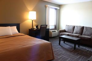 魔鬼湖Sunlac Inn Devils Lake的酒店客房,配有床和沙发