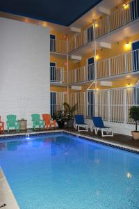 芬威克岛Seaside Inn & Suites的酒店客房的大型游泳池配有椅子