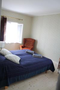 维尔扬迪Trepimäe Guest Apartment的一间卧室配有蓝色的床和橙色椅子