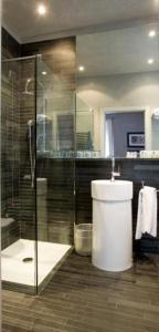 帕尔马世纪酒店的一间带卫生间和玻璃淋浴间的浴室
