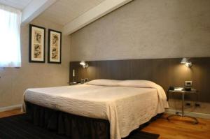 帕尔马世纪酒店的一间卧室,卧室内配有一张大床
