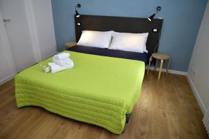 MarchenoLa Casa Ritrovata的一间卧室配有绿床和毛巾