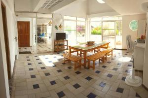 圣安德烈斯Coral House San Andres的一间铺有瓷砖地板并配有桌子和长凳的用餐室