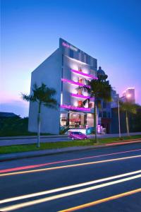 泗水泗水发富格拉古酒店的街道边有紫色灯的建筑