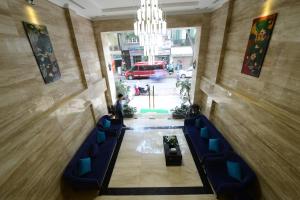 河内河内碧海Spa酒店的大楼内带蓝色椅子和吊灯的走廊