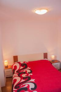 莫托文瓦伦蒂诺宾馆的一间卧室配有红色的床和红色毯子