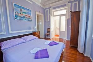 奥帕提亚Apartman Isadora的卧室配有一张带紫色枕头的大型白色床。
