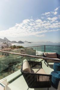 里约热内卢科帕卡巴纳丽思精品酒店的阳台配有椅子,享有海景。