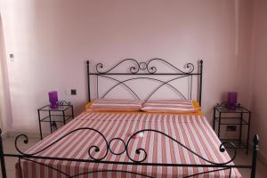 马埃岛贝拉扎尔区绿蓝海滩公寓的一张带金属框架的床和两张床头柜