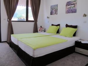 科泰尔Guest House & Bistro Lefterova的一间卧室配有一张带绿色枕头的大床