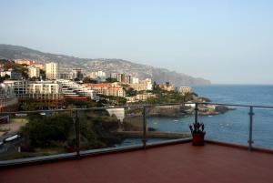 丰沙尔Apartamento do Mar的阳台享有城市和大海的景致。