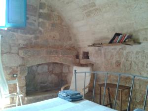 卡斯特里尼亚诺德尔卡波Trullo Nicola的客房设有带桌椅的石制壁炉。