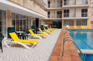 埃尔阿雷纳尔瑞陶特酒店的酒店游泳池设有黄色的椅子和桌椅