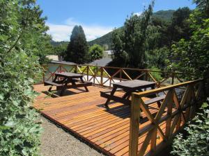 圣马丁德洛斯Apart Cascadas的木甲板上设有两张野餐桌
