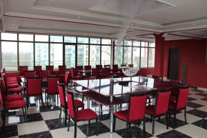 波季Hotel Park Green的一间带大桌子和红色椅子的用餐室