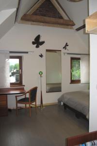Esneux石站公寓式酒店的卧室配有一张床和一张书桌,墙上挂着蝴蝶。