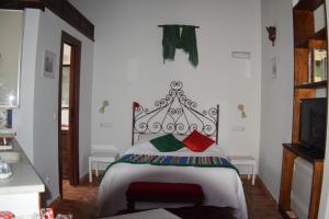格拉纳达拉米拉卡门公寓的一间卧室配有红色和绿色枕头的床