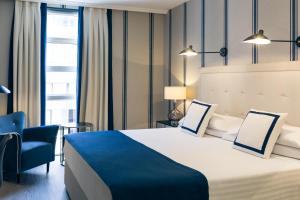毕尔巴鄂美居加迪纳斯德艾碧亚酒店的酒店客房带大床和蓝椅