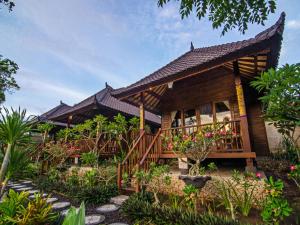 蓝梦岛卡萨哇简易别墅酒店的带阳台和一些植物的木屋