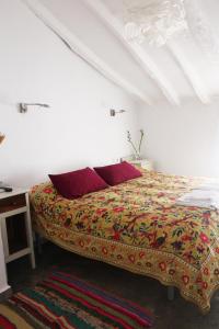 阿尔戈多纳莱斯Casa Baraka的白色客房内的一张带红色枕头的床