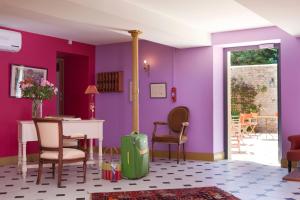 OucquesLogis hôtel Ô en Couleur的一间拥有紫色墙壁和桌椅的房间