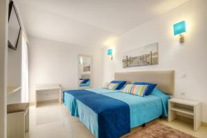 阿尔布费拉3HB Golden Beach的白色卧室配有蓝色的床和蓝色的床单