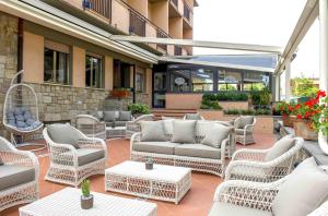 卡斯蒂里昂纳·德拉佩Hotel Anfora的庭院设有藤椅、沙发和桌子