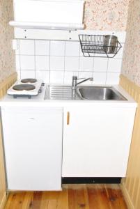 HauridaÅsens By的厨房配有白色橱柜和水槽