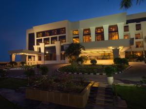 蓬蒂切里双威庄园酒店的一座白色的大建筑,晚上有庭院