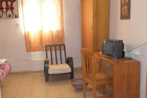 瓦加杜古自由酒店的客房设有一张桌子、一台电视和一把椅子