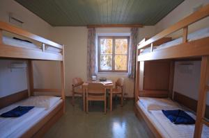 滨湖采尔滨湖采尔尤格斯酒店的客房设有一张桌子和四张双层床。