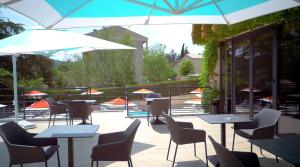 格雷乌莱班卢帕拉度酒店的一个带桌椅和遮阳伞的庭院