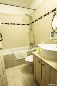 卡洛帕尼亚伊奥蒂斯安斯特传统别墅酒店的浴室配有盥洗盆、卫生间和浴缸。