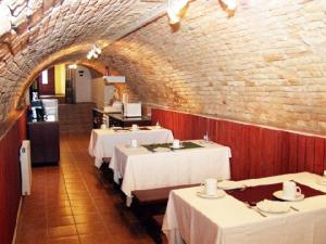艾斯特根Decsi Vendégház的一间设有白色桌子和砖墙的用餐室