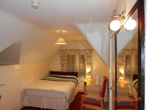 戈斯波特橡子旅馆宾馆的一间小卧室,配有一张床和一个楼梯