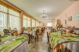 里米尼Hotel Diamante的用餐室配有桌椅和绿色餐巾
