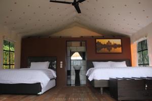 伦邦特日兹拉度假酒店 - 格拉姆营地的一间卧室配有两张床和吊扇