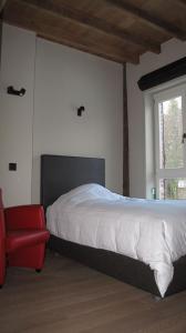 鲁汶Hotel Guesthouse Begijnhof的一间卧室配有一张床和一张红色椅子