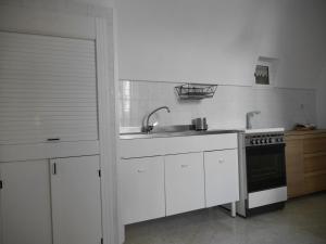 滨海波利尼亚诺La Conchiglia Domus的白色的厨房设有水槽和炉灶。