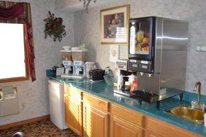 奥马哈奥马哈休闲汽车旅馆及套房的厨房配有微波炉和冰箱。