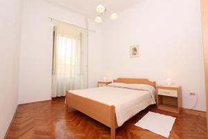 罗维尼里其公寓的白色的卧室设有床和窗户